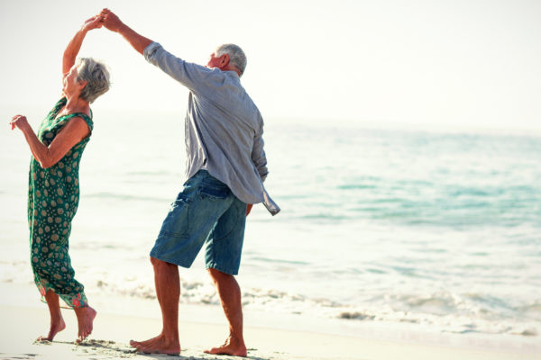 Retired couple dancing on a beach
