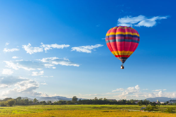 Colourful hot air balloon over a green field