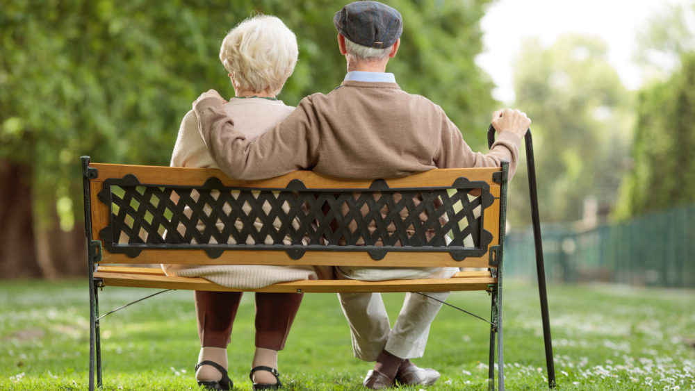 Senior couple sitting on a bench in a park