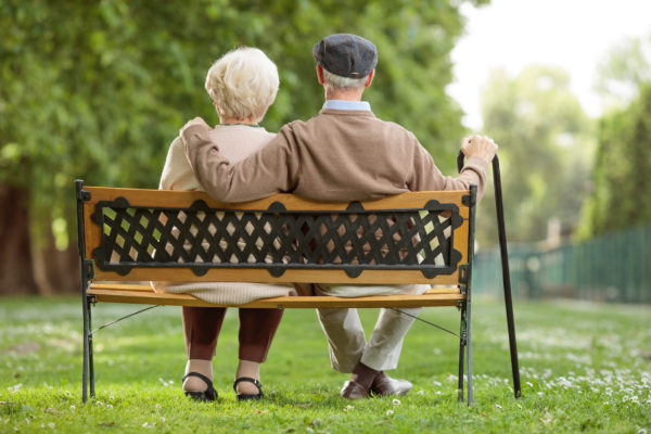 Senior couple sitting on a bench in a park
