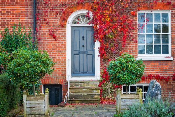 Blue front door to a home of a red-brick house