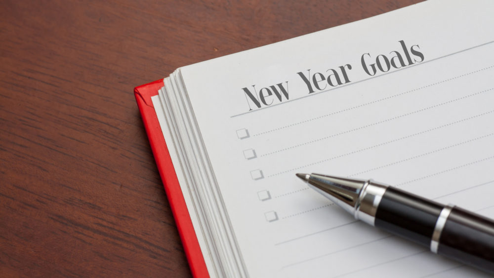 A notebook page reading “New Year Goals”