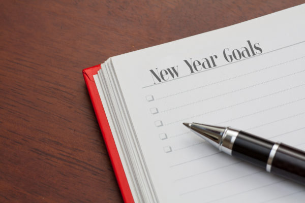 A notebook page reading “New Year Goals”