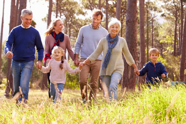 A multi-generational family walking through the countryside.