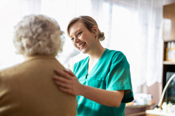 A care professional talking to a woman.