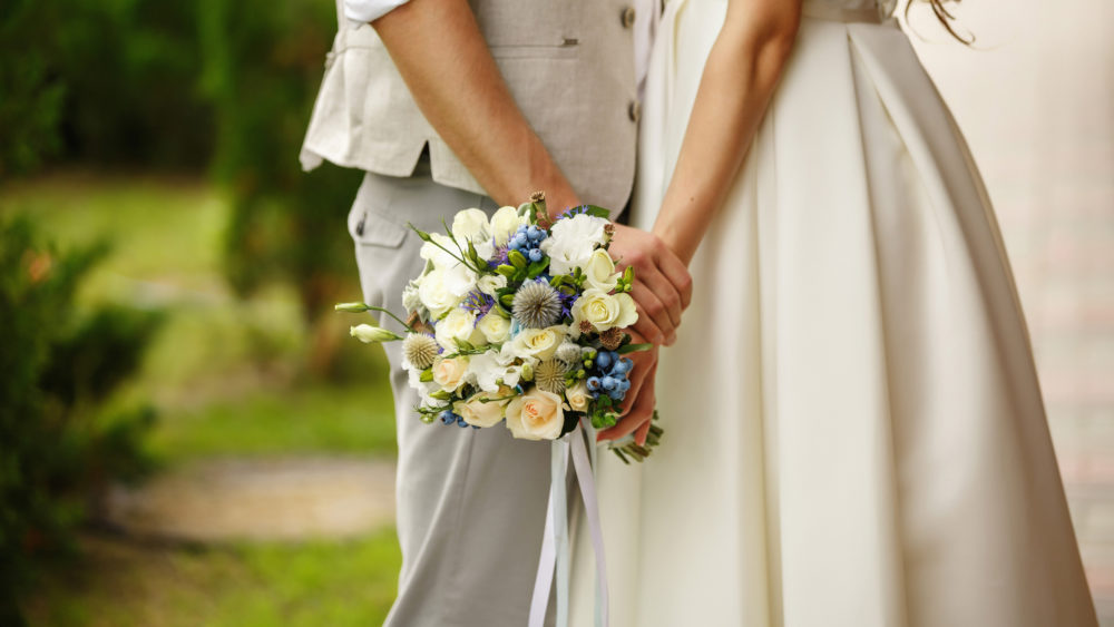 Wedding bouquet in the hands of a bride and groom.