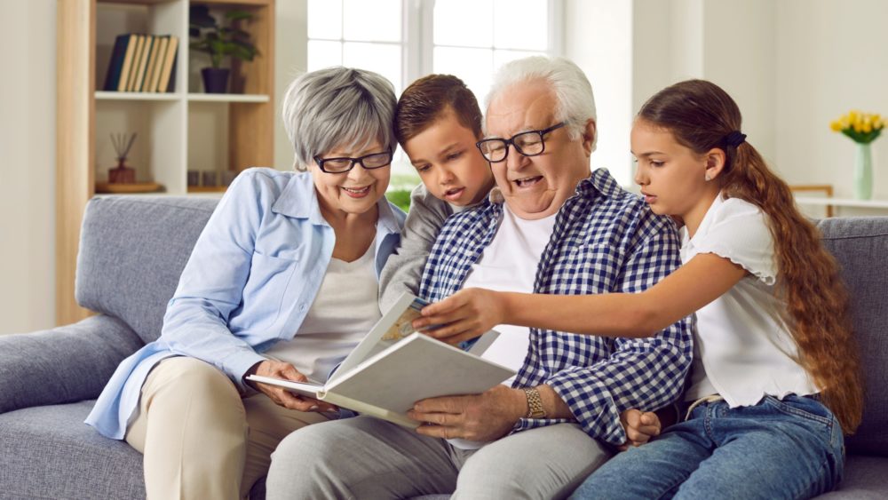 Grandparents looking at a photo album with their grandchildren.