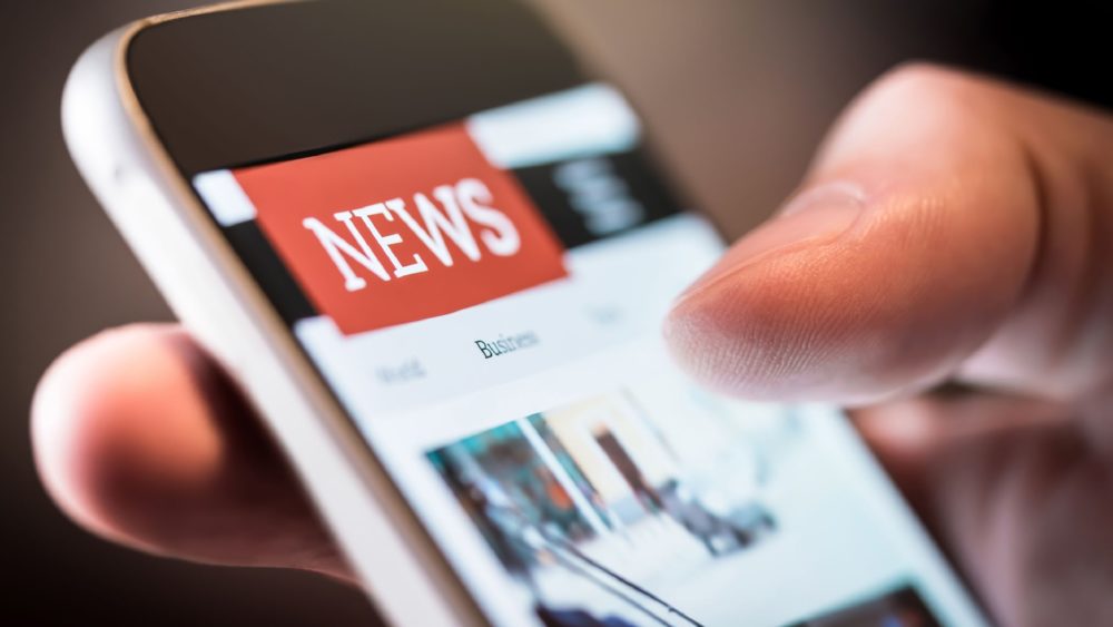 A person using a smartphone to read the news.