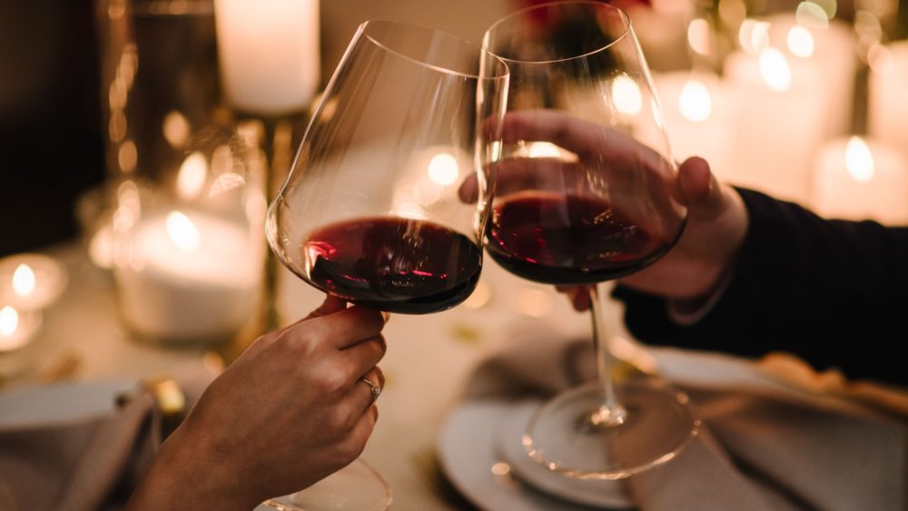 A couple toasting with a glass of wine.