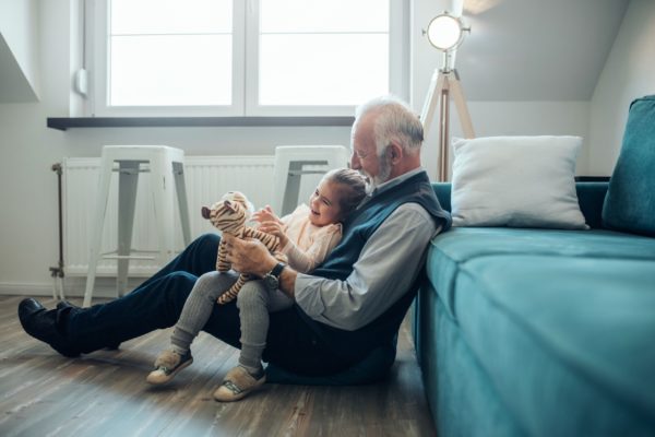 A grandfather playing with his granddaughter.