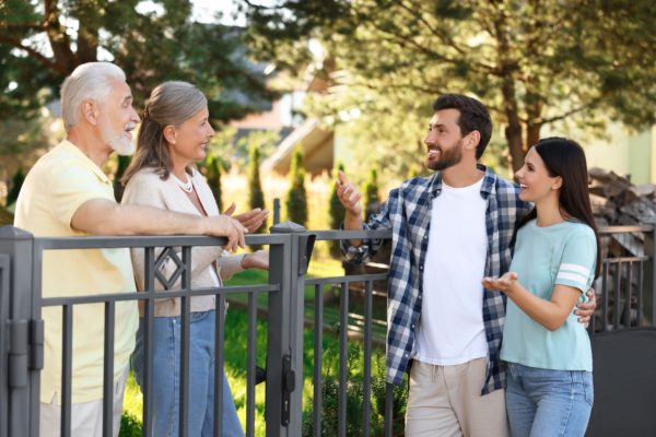 A young couple talking to their older neighbours.