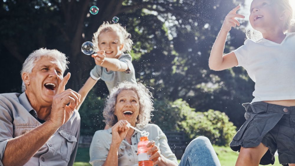 Grandparents blowing bubbles with their grandchildren.