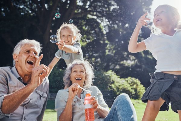 Grandparents blowing bubbles with their grandchildren.