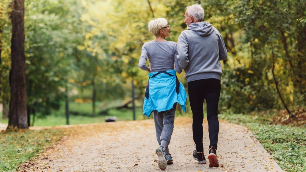 A couple jogging in a park.