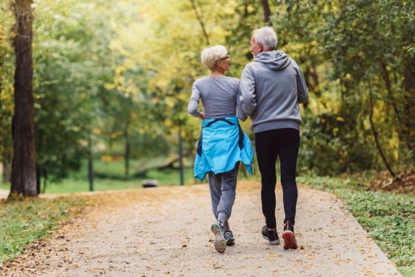 A couple jogging in a park.