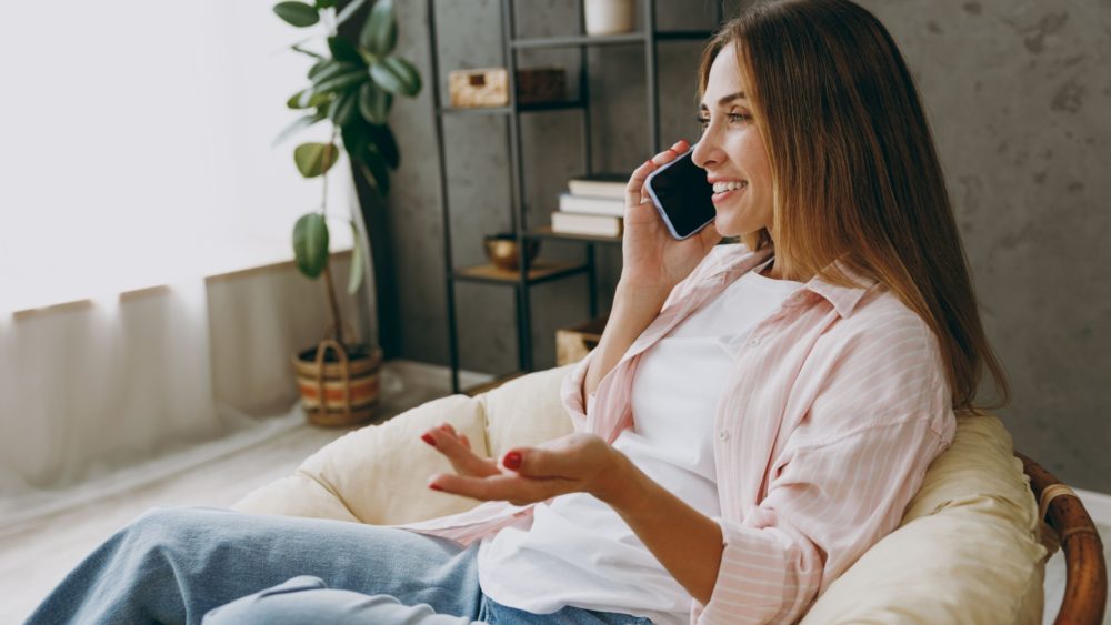 A woman talking on the phone at home.