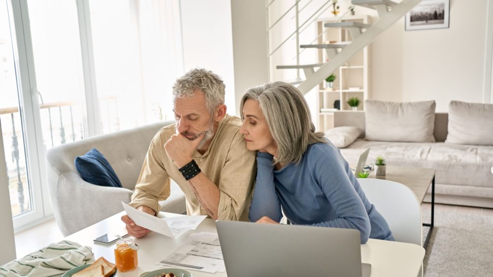 A couple looking at paperwork together in their home.