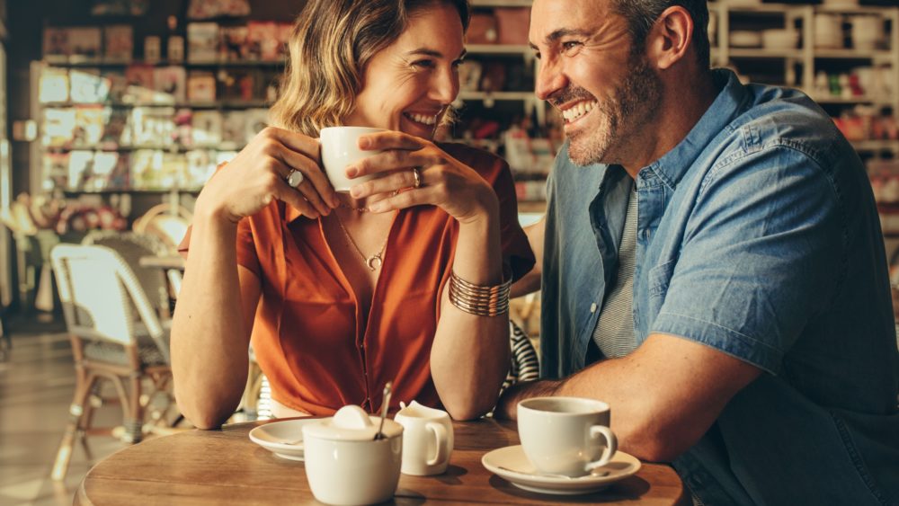 A couple laughing in a café.