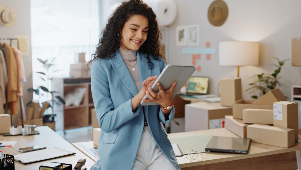 A female business owner using a tablet in an office.