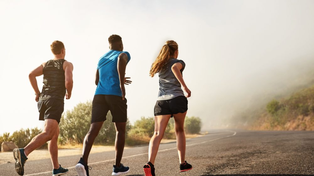 Three people running outdoors.