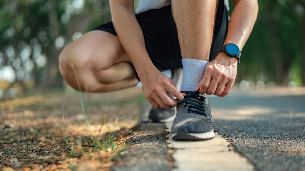 A man lacing up running shoes.