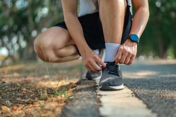 A man lacing up running shoes.