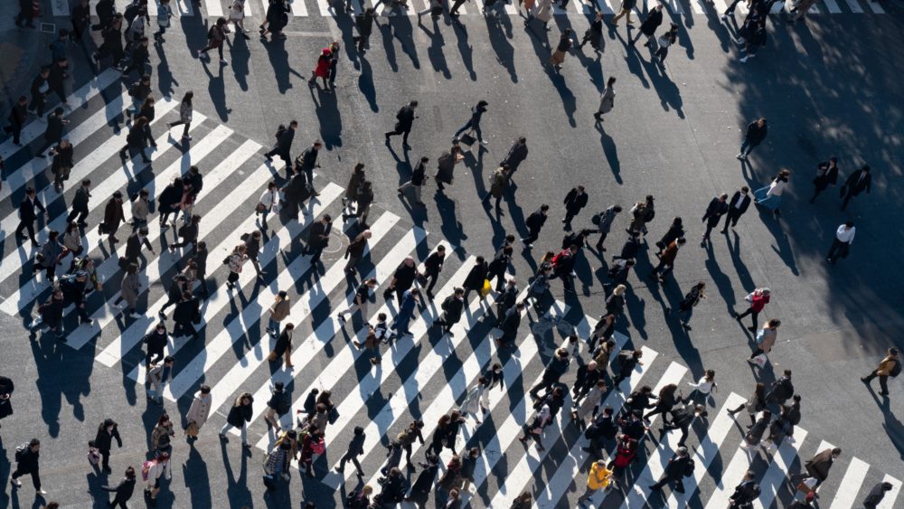 A crowd of people crossing a road.