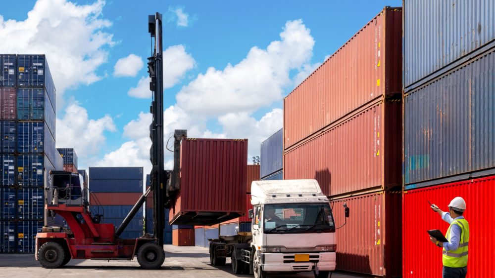 A foreman organising containers from a cargo ship.