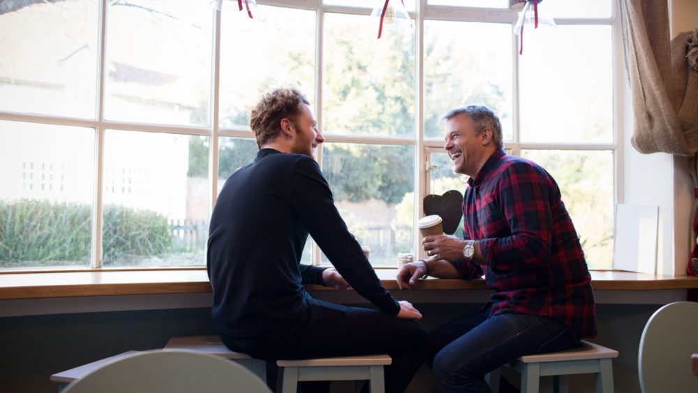 Two men taking in a coffee shop.