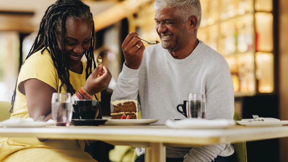 A couple laughing together at a café.