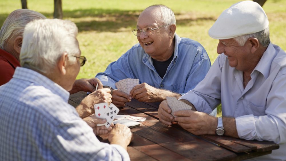 A group of friends playing cards outdoors.