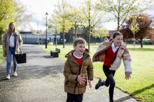A mum and two children walking home from school.