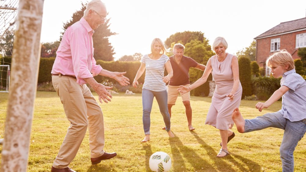 A family playing football in a garden.