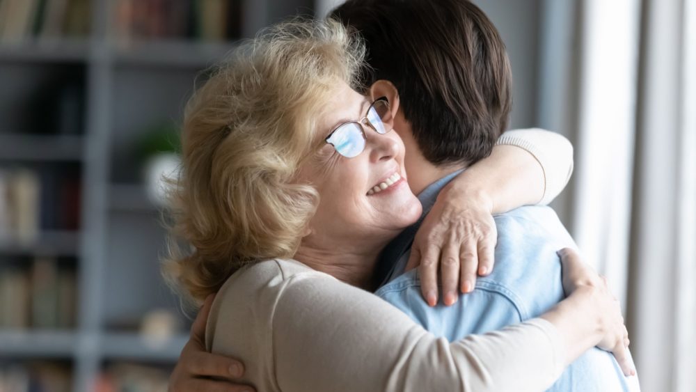 A mother hugging her adult son.