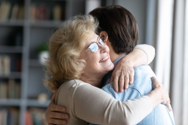 A mother hugging her adult son.