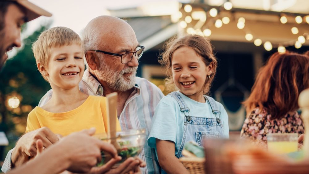 A grandfather laughing with his grandchildren.