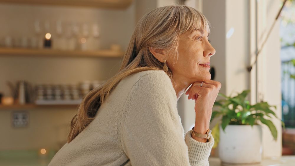 A woman looking out of the window at home.