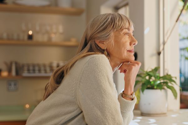 A woman looking out of the window at home.
