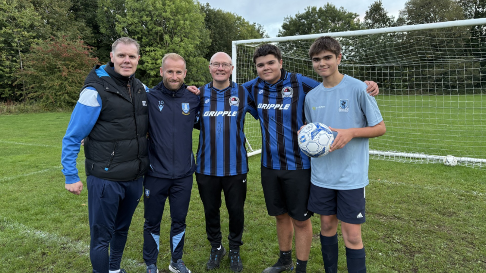 Some of the team stood together in front of the goal